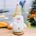 Gnome de Noël festif en peluche avec bonnet blanc et doré sur un socle en bois - Père Noël