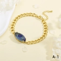 Primo piano di un bracciale a catena dorata con ciondolo occhio greco blu e chiusura a moschettone - Stile Occhio Blu (BR1818-A-1)