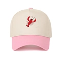 Close-up of red lobster embroidery on a beige and pink cotton baseball cap - Pink