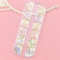 Flat lay of floral and butterfly nail art charms in a 12-slot clear storage box - White Colorful Mixed Decoration Style (T-345)