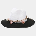 Detail of the woven straw hat with contrasting black brim and small seashell ornaments - White with Black Brim