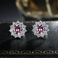 Macro shot of silver sunflower stud earrings with pink zircon and white pavé stones - Pink