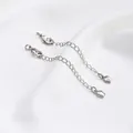 Detail of silver extender chains with lobster clasps and tulip pendants on white silk - White Gold Color Flower Bud