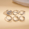Detalle macro del juego de seis anillos plateados con formas líquidas irregulares - Plata (Juego de 5 piezas)
