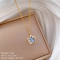 Detalle del colgante de estrella dorada con cristales azules sobre joyero y seda blanca - Forma de Estrella (G139) / Dorado
