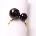Detail view of matte gold napkin ring featuring two elegant black spherical pearls - Black (Gold Ring)