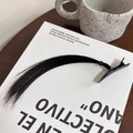 Single piece black straight hair extension clip on a minimalist book background - Black Brown