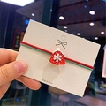 Dettaglio di elastico per capelli natalizio con cordini rosso-verdi e ciondolo a campanella - Campana di Natale