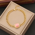 Golden Cuban chain necklace with square pink cat's eye stone pendant on jewelry box - Bracelet