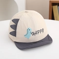 Detail van het blauwe dinosaurusborduurwerk en 3D-stekels op de beige katoenen babycap - 48cm (6-20 Maanden) / Grijs