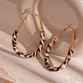 Detailed view of hoop earrings with leopard print leather texture and golden metal accents - Brown Leopard Oval (925 Silver Pin)