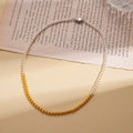 Détail du collier avec perles blanches et perles dorées sur des pages de livre vintage - 4mm / Jaune (Collier-4mm)