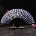 Detailed close-up of a Japanese folding fan featuring cherry blossom and butterfly patterns - Black Cherry Blossom Butterfly