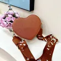 Brown heart-shaped crossbody bag with a wide patterned strap and leather texture - Brown