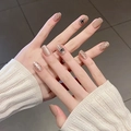 Close-up of nude press-on nails with 3D bow and polka dot patterns on hands - By1734 Yanzi Yanzhi / Phototherapy Glue Style