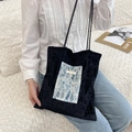 Close-up of velvet tote bag featuring blue lace embroidery details and slim shoulder strap - Blue Lace + Black Velvet