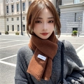 Detailed view of brown rib-knit scarf texture featuring a small white brand label - Tan