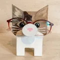 Dettaglio portaocchiali in legno a forma di gatto con occhiali rossi sulla base - Gatto