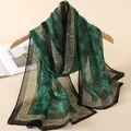 Detail of green floral and leopard print chiffon scarf draped on a wooden hanger - Green Leopard Border