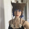 Brown crochet cat ear hat with devil horns and star pendants worn by a model - Adult 56-59cm / Brown