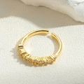 Dettaglio ravvicinato di anello dorato regolabile con sette pietre di zirconi lucidi - Fila Minimalista di Sette Pietre