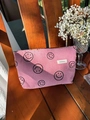 Dettaglio della borsa cosmetica in velluto rosa con stampa smiley su sedia in legno - Rosa