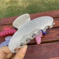 Sparkling silver glitter acetate hair claw clip with seven teeth shown on a wooden bench - Seven Teeth Claw / Grey Glitter