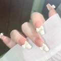 Detailansicht eleganter French-Tip-Aufklebenägel mit weißen 3D-Schleifen-Akzenten. - Cremegelbe Schleife (Z420)
