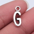 Silver alloy letter G pendant charm for DIY jewelry making shown held in hand - Letter G (B15660) / Antique Silver
