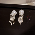 Macro shot of silver pearl tassel earrings with shimmering rhinestone fringe detail - Gold