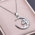 Primer plano de colgante de luna creciente y calavera plateada en caja de joyas - Collar con Colgante Color Plata
