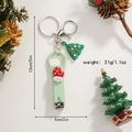 Detailed view of Santa Christmas tree nail clipper keychain with holiday pinecone decor - Glove Style