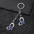 Close-up of vintage alloy keychain with silver heart pendants and blue evil eye beads - Double Heart Eye