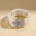 Detalle de pulsera de perlas de tres capas con una flor de cristal brillante central - Pulsera de varias capas - Blanco