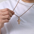 Close-up of gold-plated stainless steel cross necklace on male model wearing white T-shirt - Rose Gold Single Pendant (No Chain)