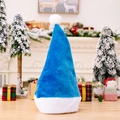 Hochwertige blaue Plüsch-Weihnachtsmütze mit weißem Rand auf festlichem Holztisch - Blau