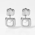 Macro view of geometric stainless steel square pendant earrings with white pearl detail - Silver (D2990)