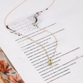 Detailed close-up of a vintage S925 silver gold necklace with a green olive gemstone - 925 Silver / Green Olive Necklace
