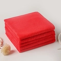 Pila di quattro panni in microfibra quadrati rossi con accessori decorativi - Rosso