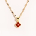 Close-up of golden necklace with a red four-leaf clover pendant and ruby stone inlay - Clover Red
