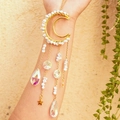 Golden moon suncatcher with white crystals and tiny star pendants worn on arm - White Howlite with Octagonal Beads & Crystal Teardrop