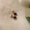 Detailansicht goldfarbener Ohrringe mit blauen Blüten und kleinen weißen Perlen auf Samt - Silberstift - Blaue Blume