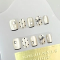 Detailed view of nude cat-eye press-on nails with silver hearts and black line edges - By1627 Has Delicate Features / Glue Type