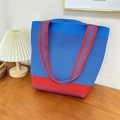 Detail shot of a knit tote bag with red and blue patterns on a warm wooden table - 25 Small N Blue