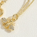 Makroaufnahme der goldenen Bienen-Halskette mit filigranem Besatz aus Zirkonia-Steinen - Goldene Biene