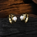 Elegant gold pearl hoop earrings shown on a rustic wooden surface in high detail - Gold