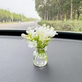 White artificial flower car vase ornament with 'Good Luck' label on car dashboard - White Bell Flower