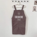 Close-up of brown cotton linen apron with Executive Chef print and large front pockets - EXECUTIVE Grey
