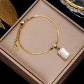 Elegant gold snake chain bracelet with square white shell pendant on jewelry box - Gold Snake Chain with White Shell Rectangle Pendant