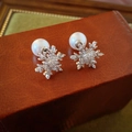 Primer plano de aretes de copo de nieve plateados con circonitas y perlas en caja cuero - Pendientes de Botón de Circonita con Copo de Nieve Plateado (HE17616)